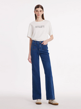a lady in denim flared jeans with white T-shirt and sneaker